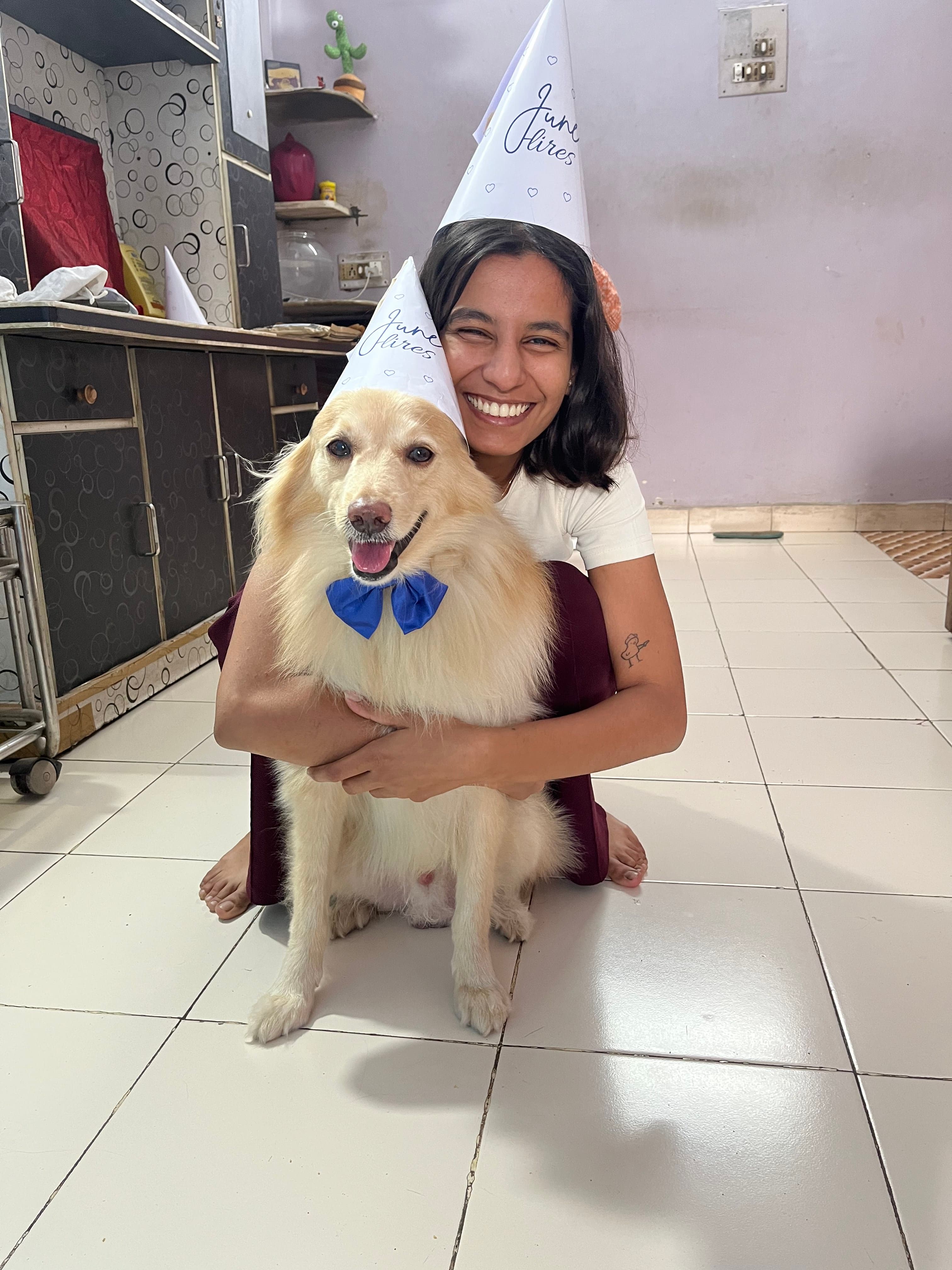 Rashmi Singh with June, both wearing JuneHires party hats; June in a blue bow tie.